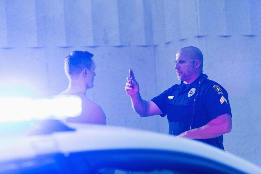 cop giving a dui assessment with lights on