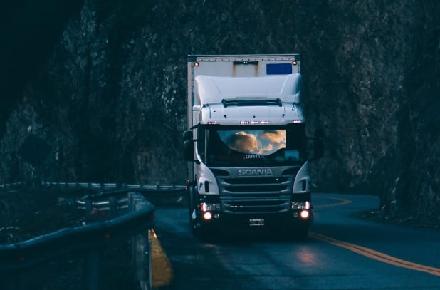 semi truck driving towards camera on a mountain curve