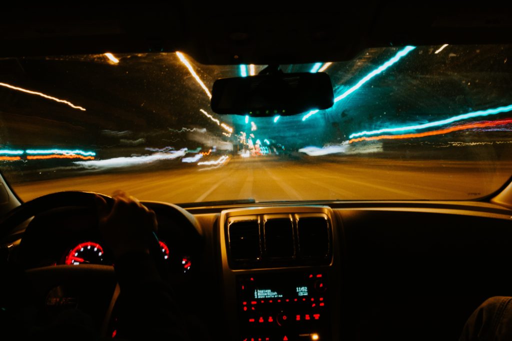 image inside a car showing trails of lights from speeding