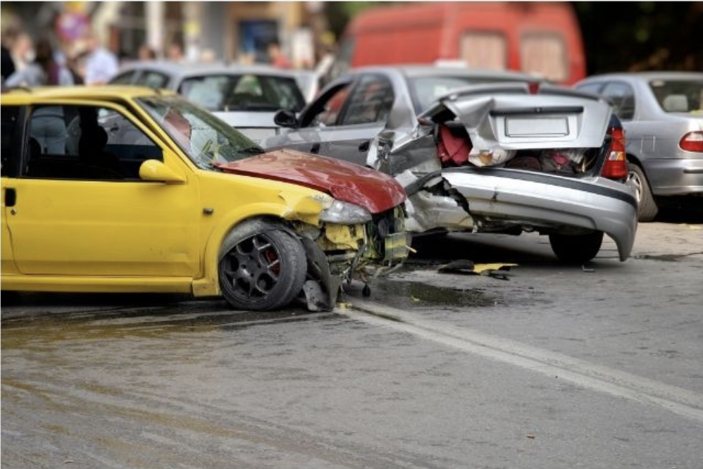 yellow car with red hood crashed into a silver car, looks to be rear ended