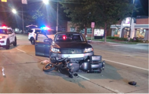 night time car accident with motorcycle in front of the car with police cars behind the accident image 2