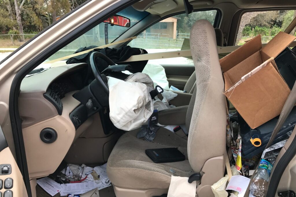 the inside of a DUI crash vehicle, driver side point of view, airbag is deployed