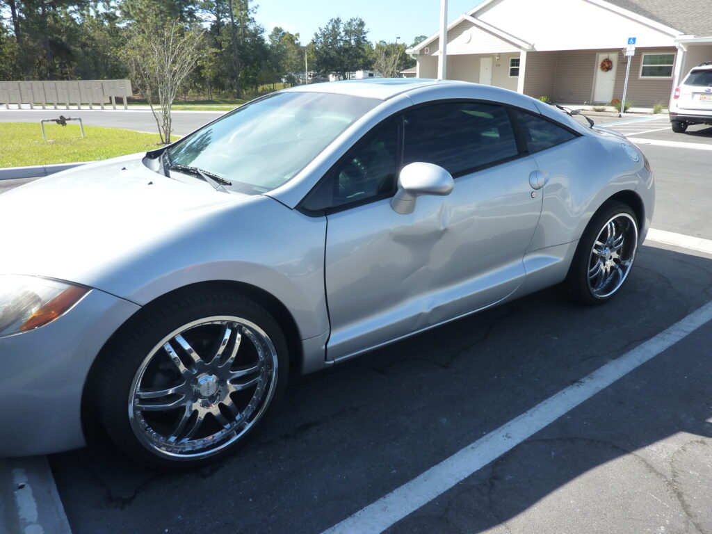 parking lot accident, sideswipe car accident in florida, damaged silver car drivers side door dented.