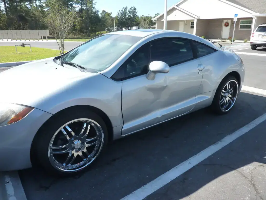 parking lot accident, sideswipe car accident in florida, damaged silver car drivers side door dented.