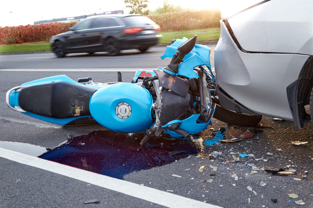 motorcycle accident on the road. damaged blue motorcycle laying on its side.