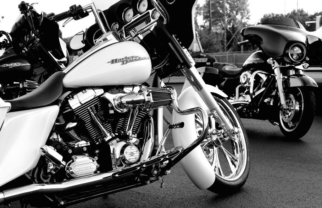 Grayscale of a rare white Harley Davidson motorcycle on the road
