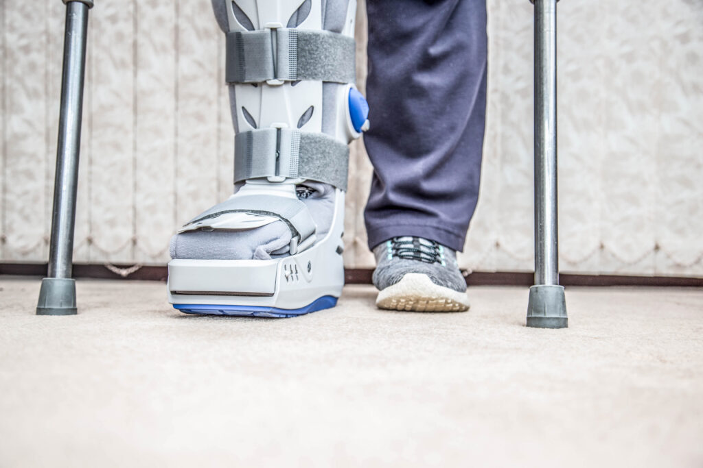 mature woman with leg brace and crutches after an auto accident