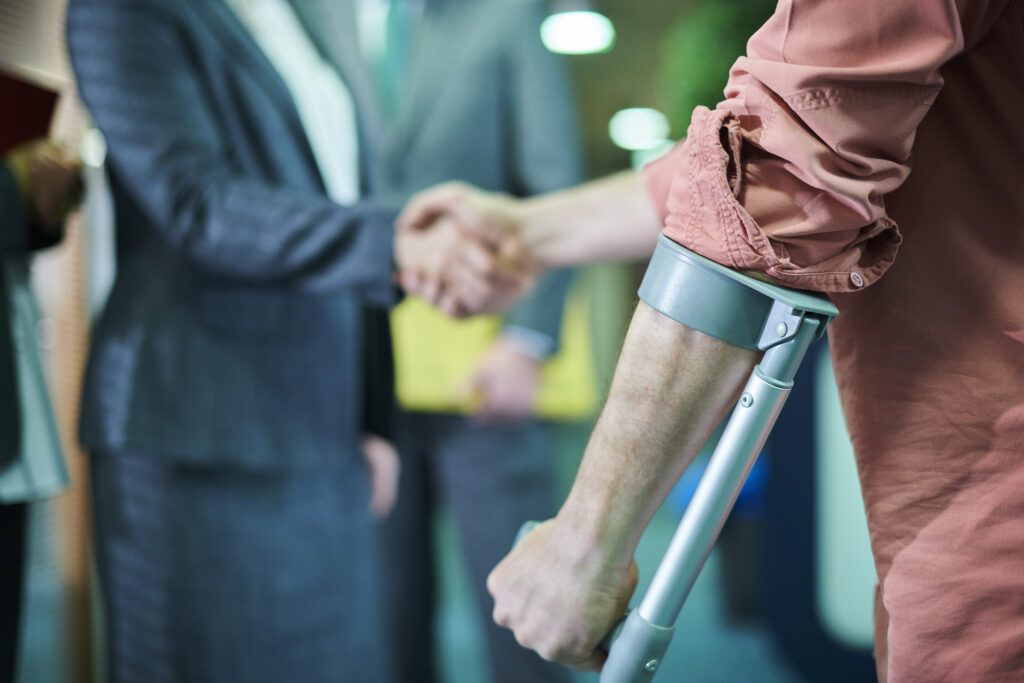 an injured man with a walking crutch shaking a personal injury lawyers hand in florida