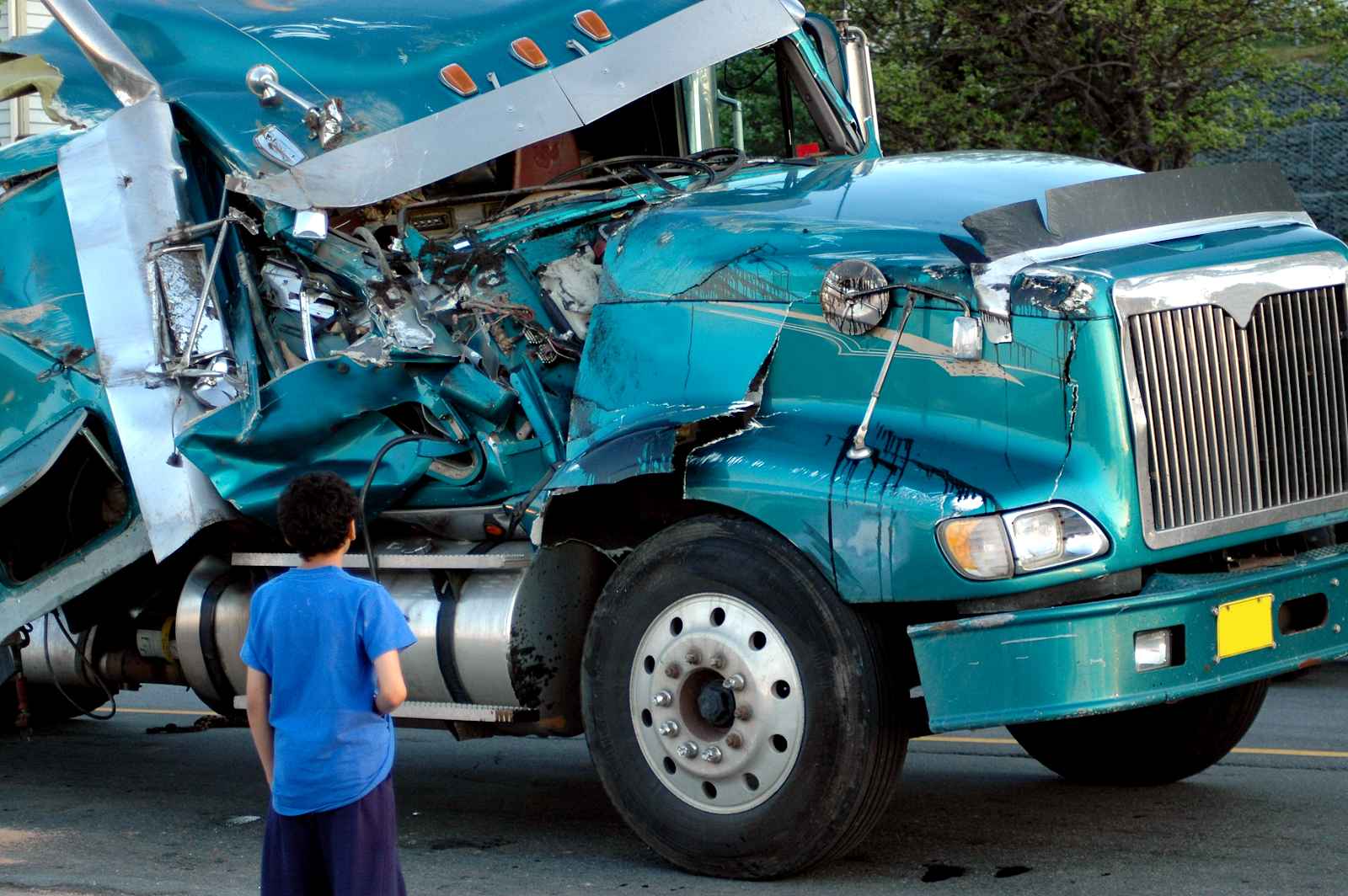 man looking at the front left side of a damaged semi truck in new port richey, new port richey truck accident scene