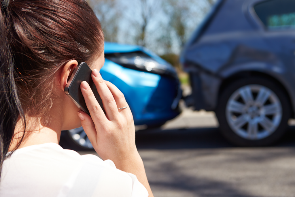 woman on the phone looking at a rear end accident, calling for PIP insurance protection in Florida