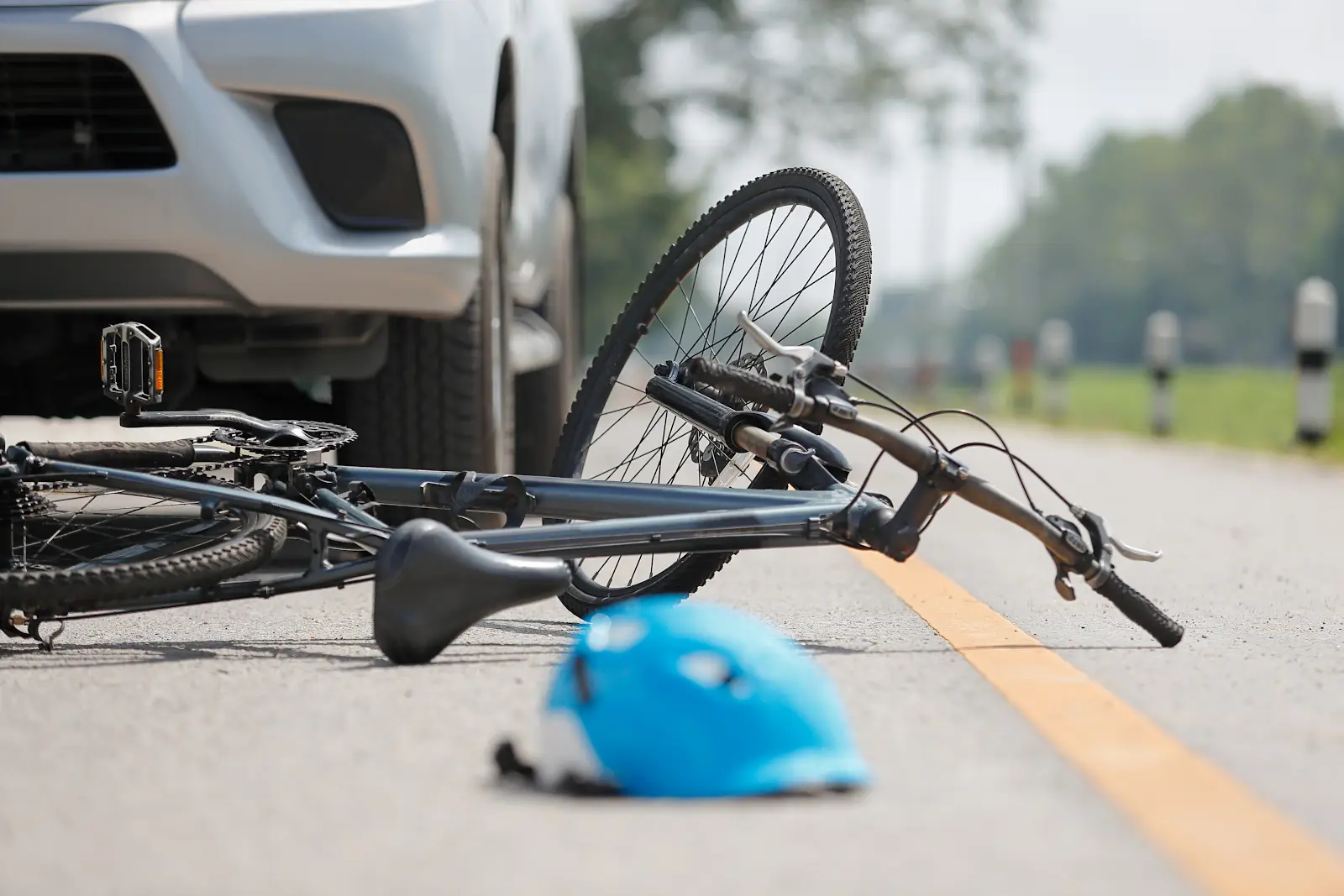 a bicycle accident scene in need of a clearwater bicycle accident lawyer to prove fault, a bike laying on the road with a car behind it.