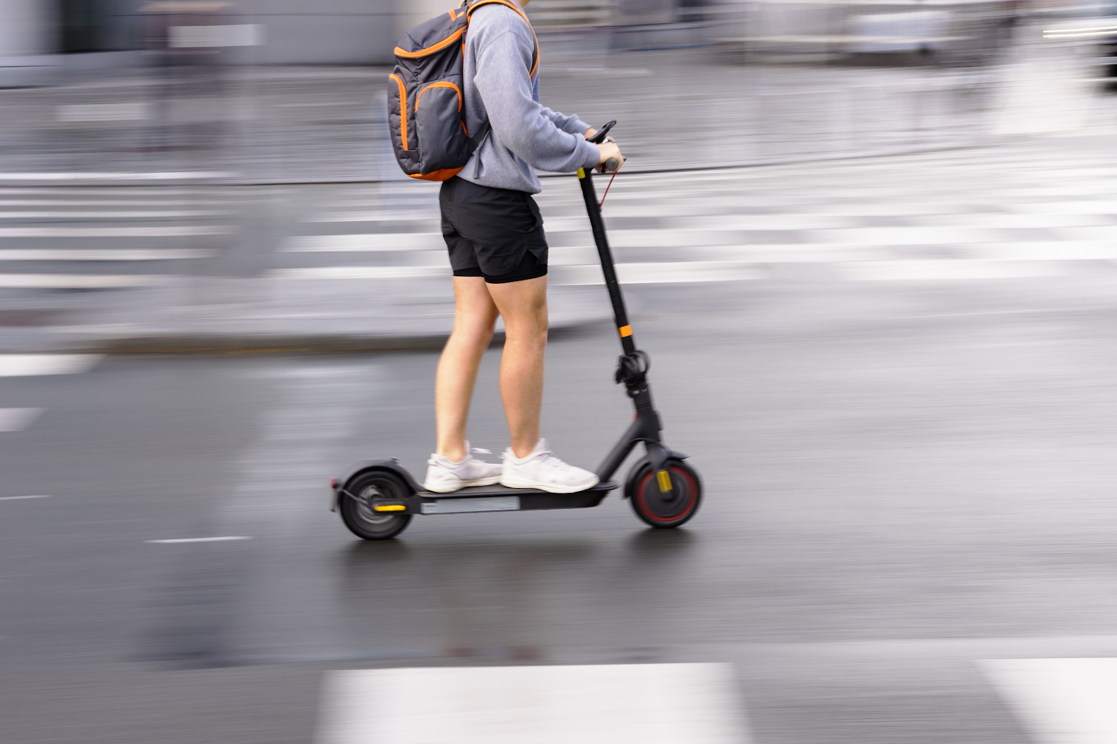 woman rides an e scooter through the street, safety concerns for severe injuries when riding e scooters