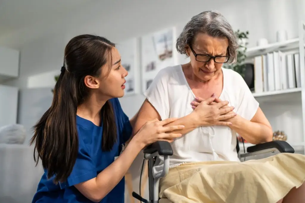 An elderly woman receives care from her nurse. She is in the hospital having chest pains after a car accident.