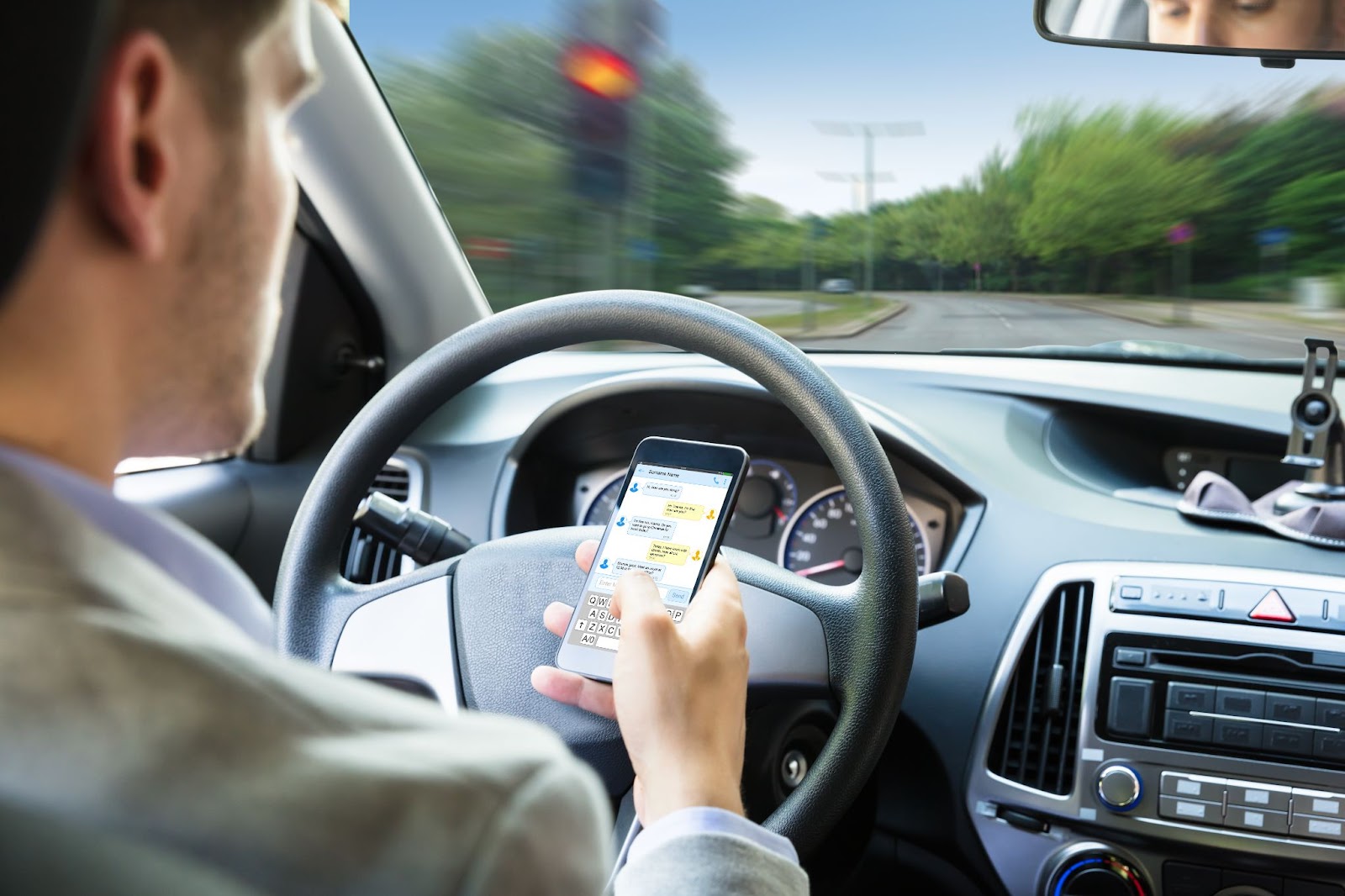 A man checks his text messages while driving.