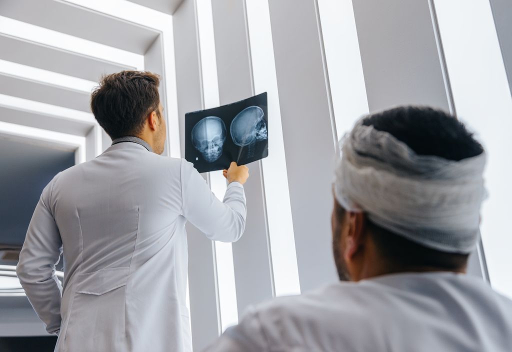 A doctor reviews a brain scan with a patient that was in a car accident.