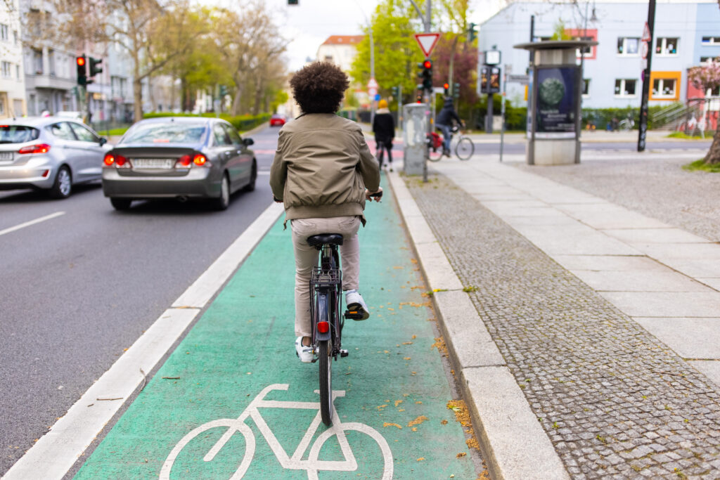 A cyclist rides down the road in a bicycle lane.