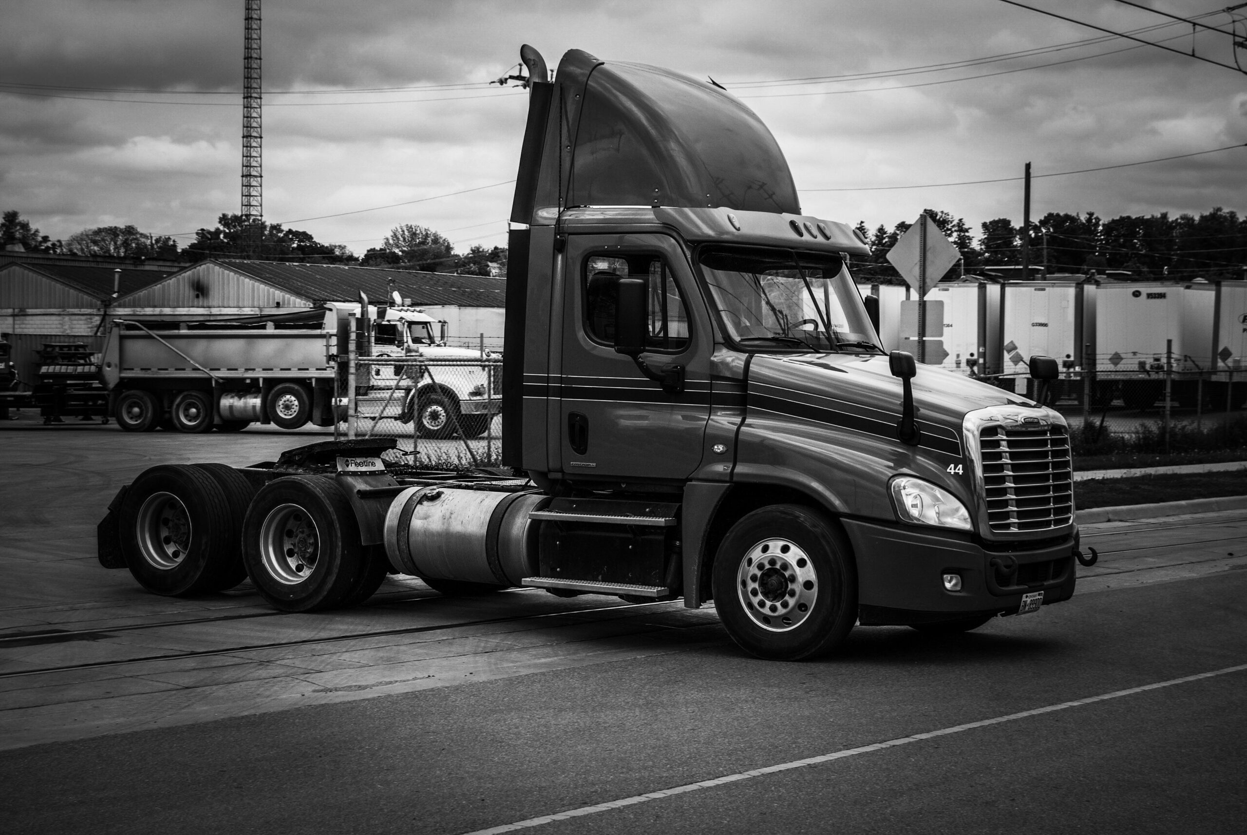 A bobtail truck drives out of a shipping facility.