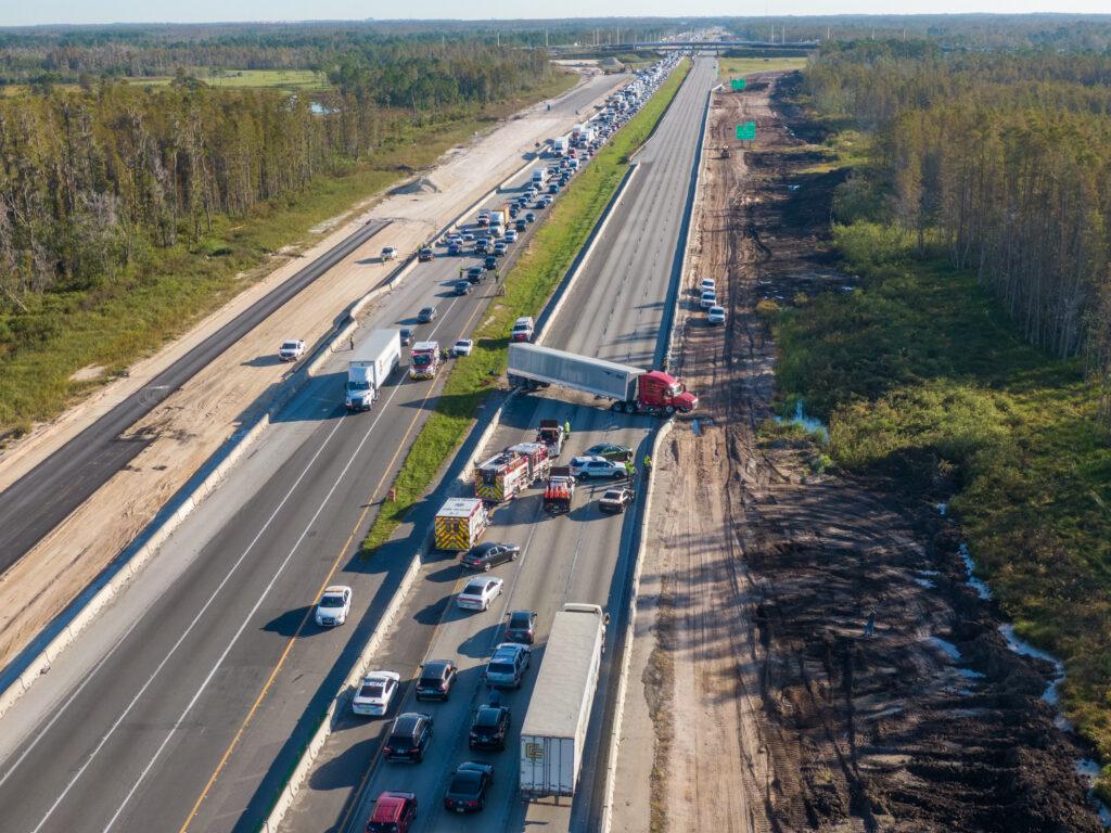 An aerial view of a fatal truck accident on I-4 in Florida that has traffic at a standstill in both directions while emergency vehicles tend to the scene.